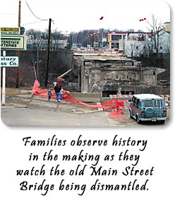 Families observe history in the making as they watch the old Main Street Bridge being dismantled.