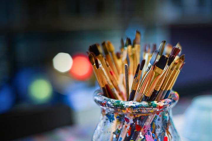 Photo: Artists' brushes in a paint covered jar. 